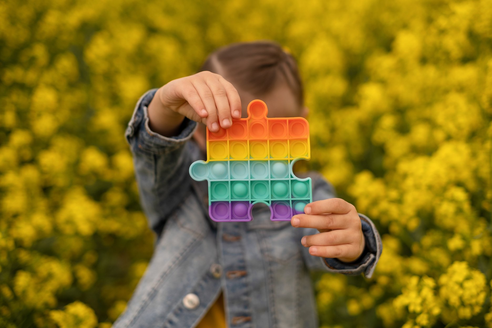 Little Child Holding Sensory Toy Outdoors